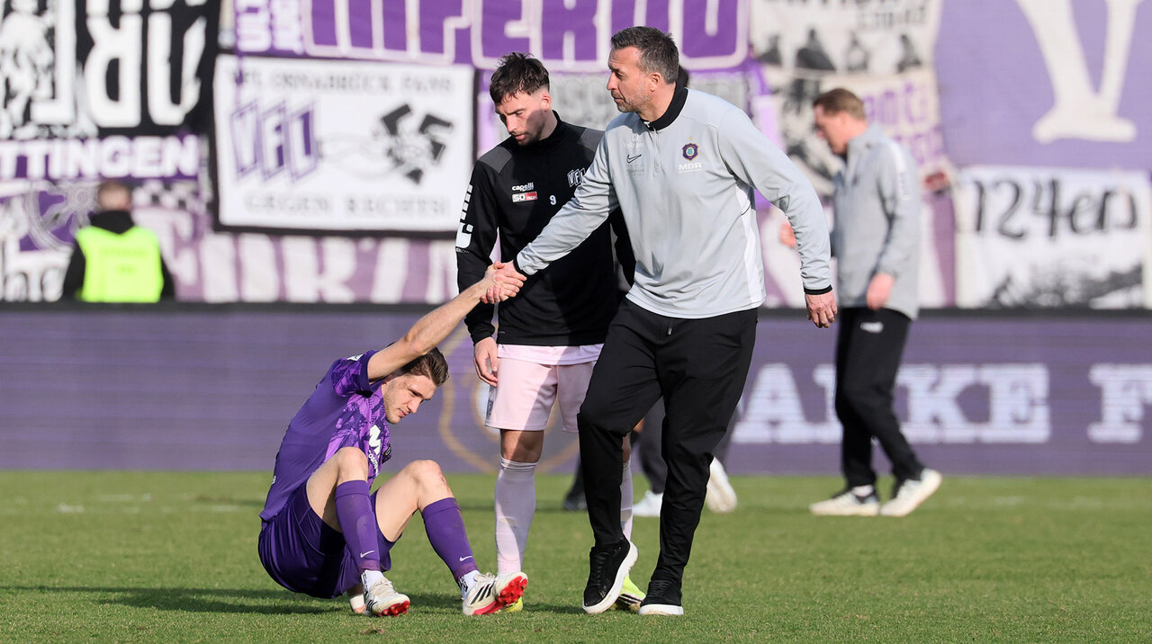 Trainer hilt Spieler hoch.