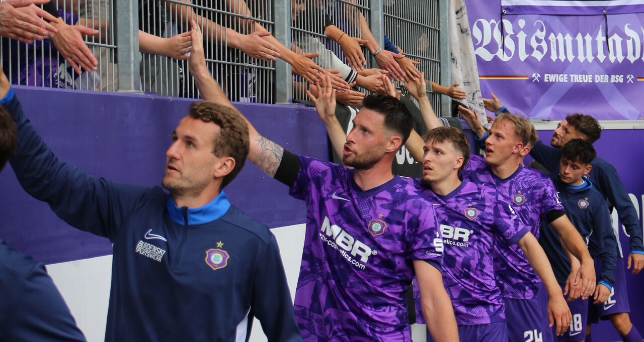 Mannschaft klatscht mit Fans ab.